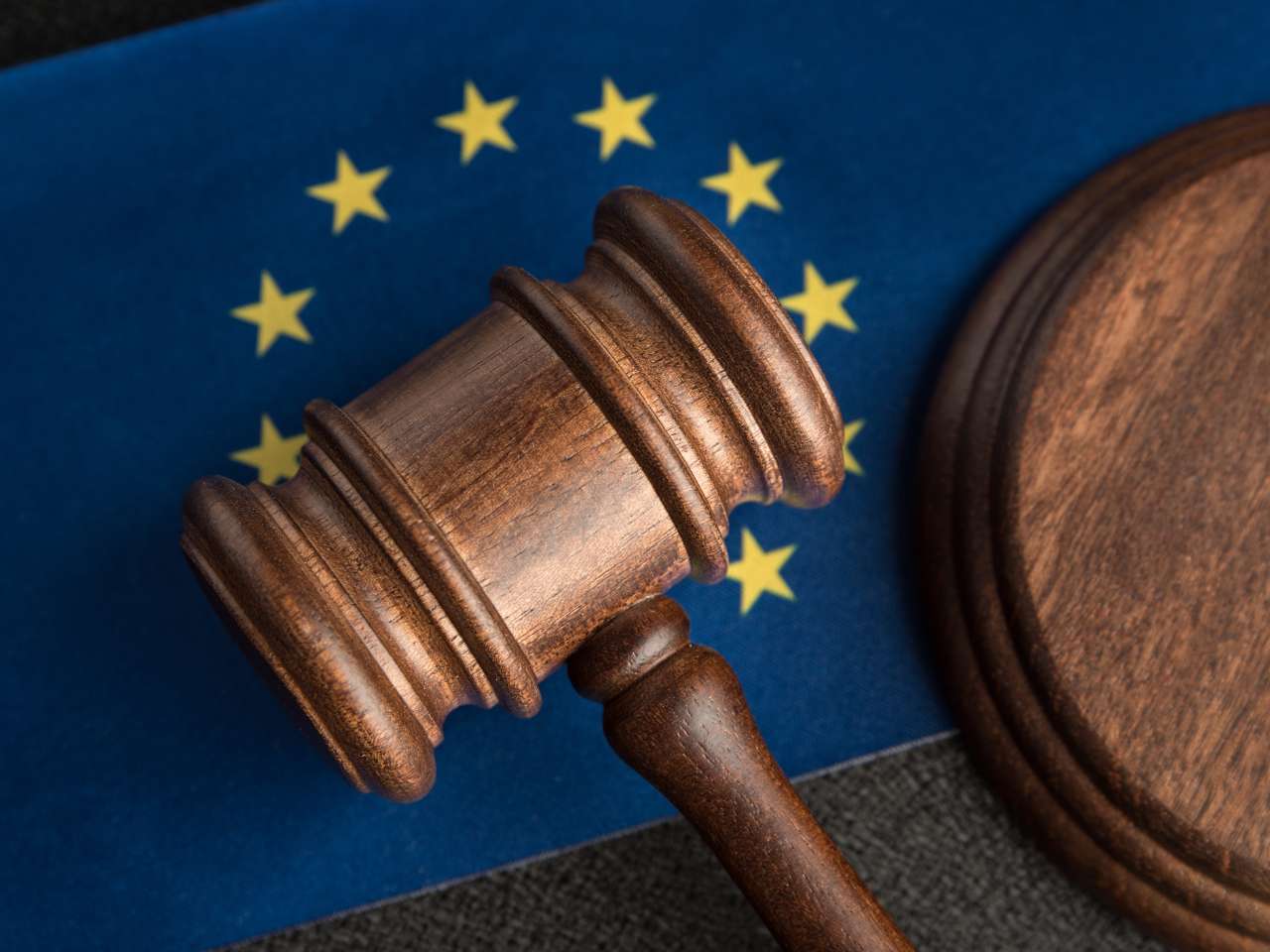 UE-mlotek-sedziowski flaga Unii Europejskiej, na której leży młotek sędziowski