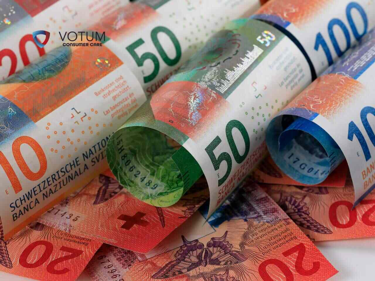 <br />
Zbliżenie przedstawia zwinięte banknoty franków szwajcarskich o różnych nominałach (20, 50, 100), ułożone na innych banknotach