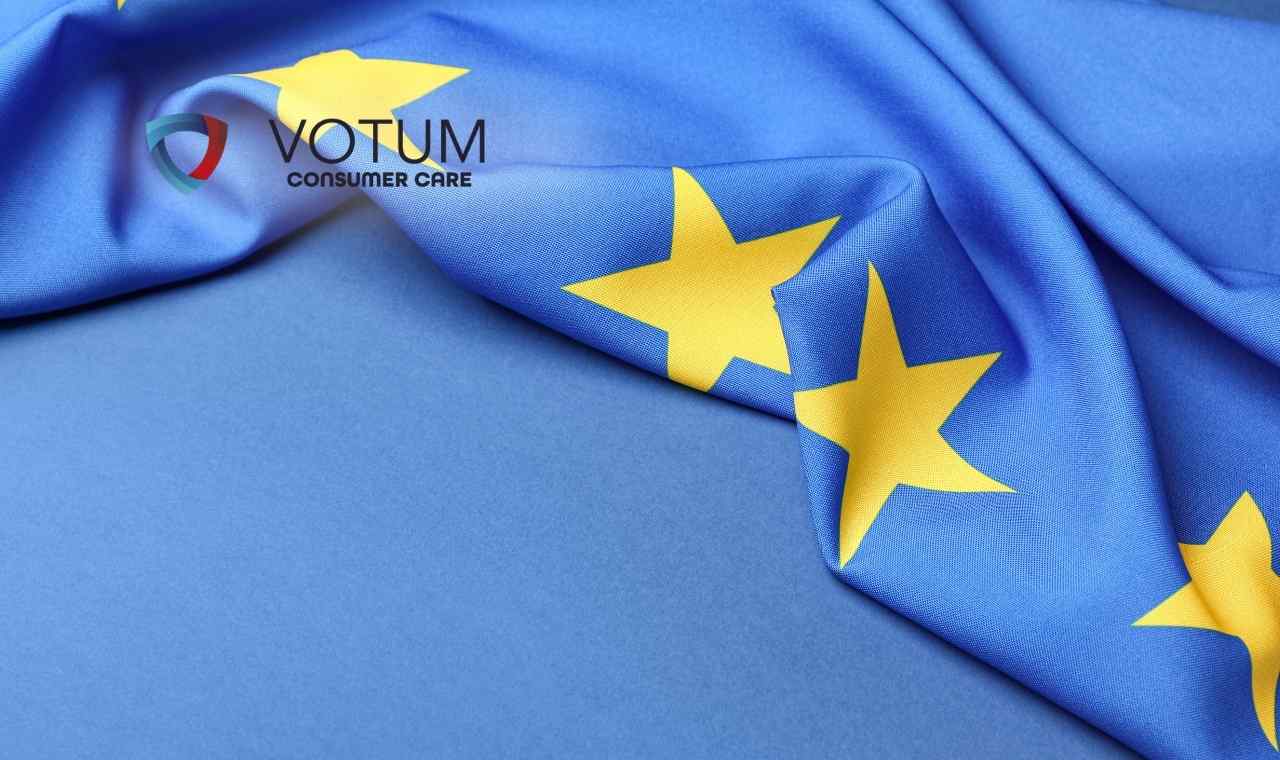 Zbliżenie na pofałdowaną flagę Unii Europejskiej z charakterystycznymi żółtymi gwiazdami
