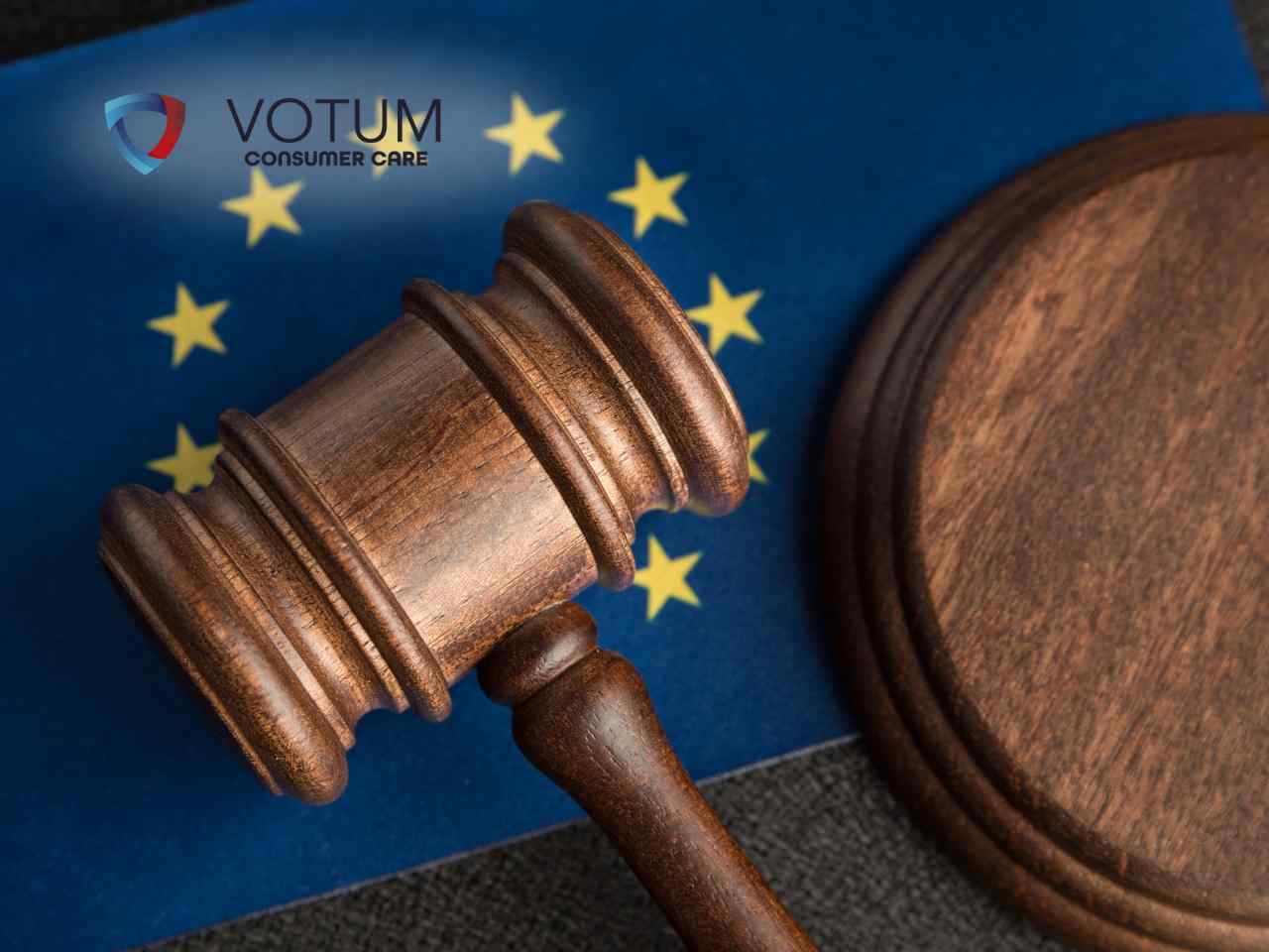Drewniany młotek sędziowski spoczywający na tle flagi Unii Europejskiej