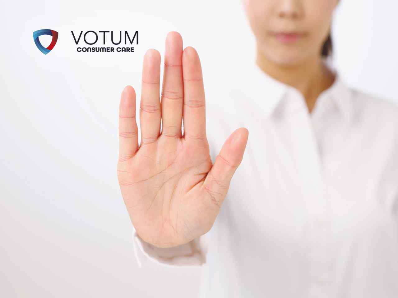 Osoba w białej koszuli wykonuje gest „stop” otwartą dłonią skierowaną w stronę obiektywu
