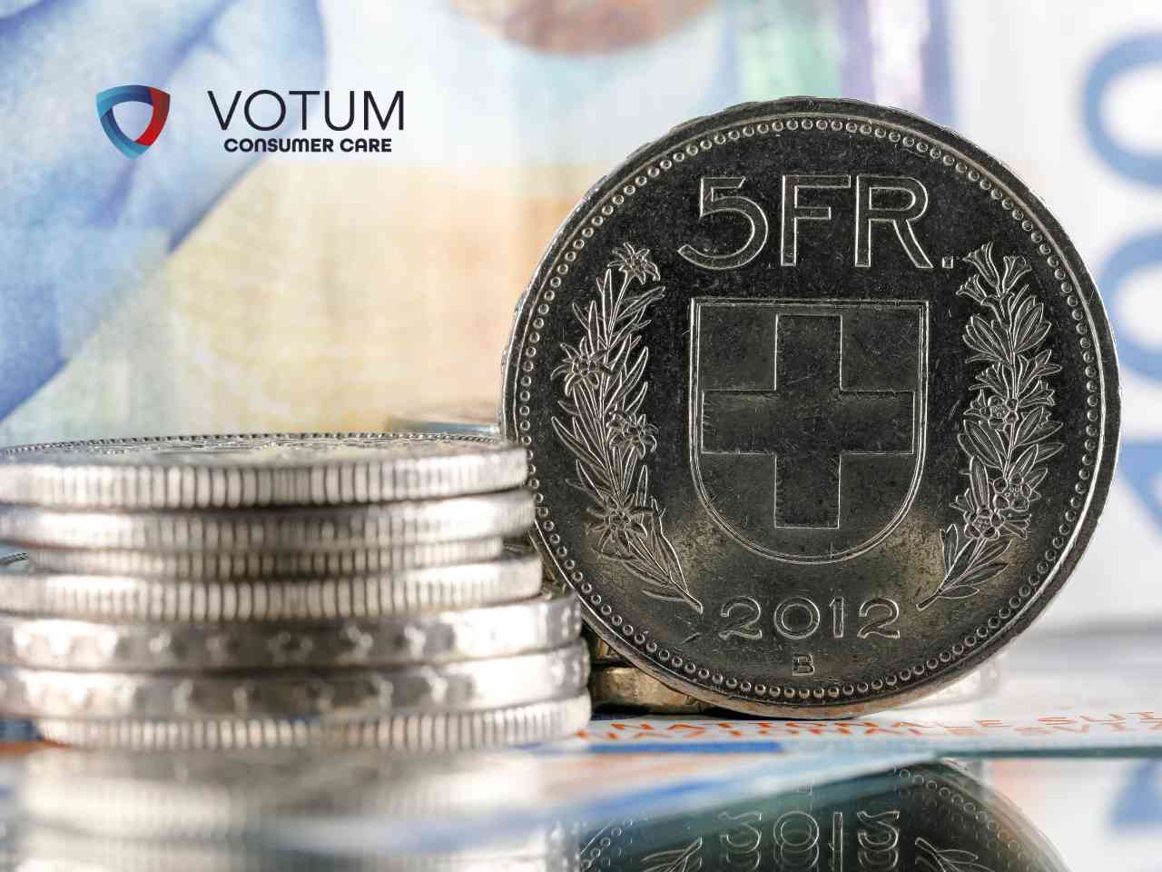 szwajcarski-frank-kredyt Srebrna moneta o nominale 5 franków szwajcarskich na tle banknotów