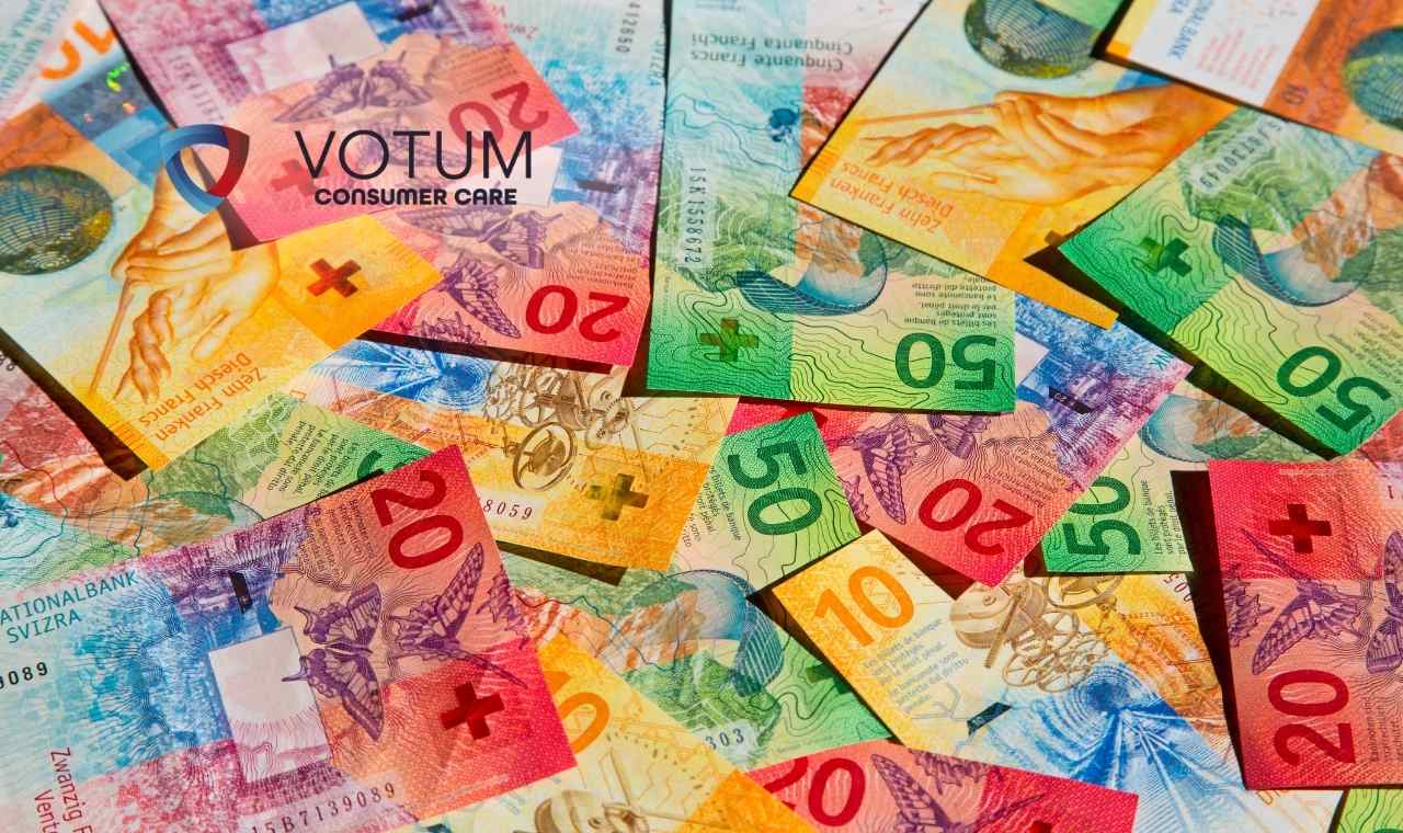 Rozrzucone, kolorowe banknoty franków szwajcarskich o różnych nominałach, tworzące gęste tło symbolizujące rozliczenia walutowe.