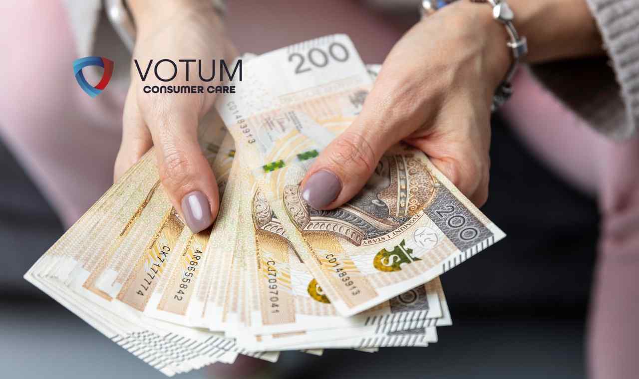 Zbliżenie na dłonie kobiety, która trzyma rozłożony wachlarz banknotów o nominale 200 złotych polskich (PLN).