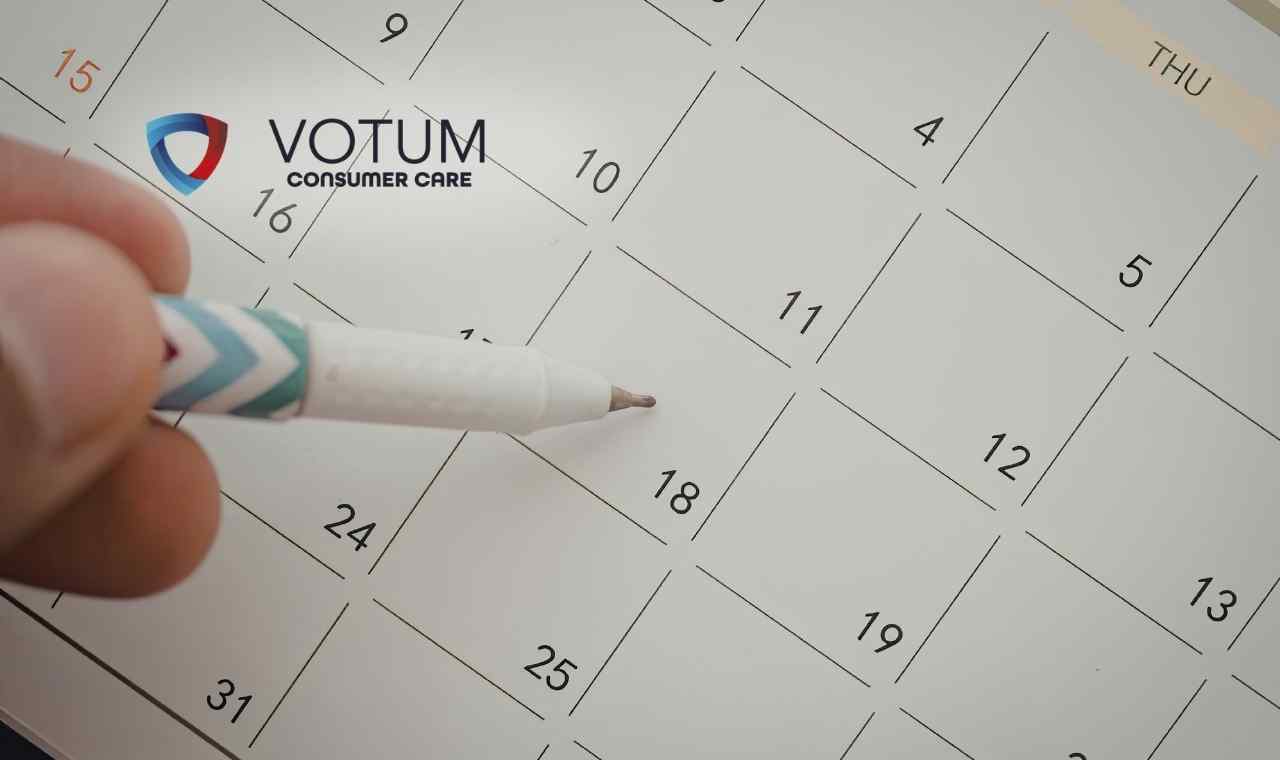 Zbliżenie na kartkę z kalendarza, na której dłoń trzymająca biały długopis wskazuje na datę „17”.