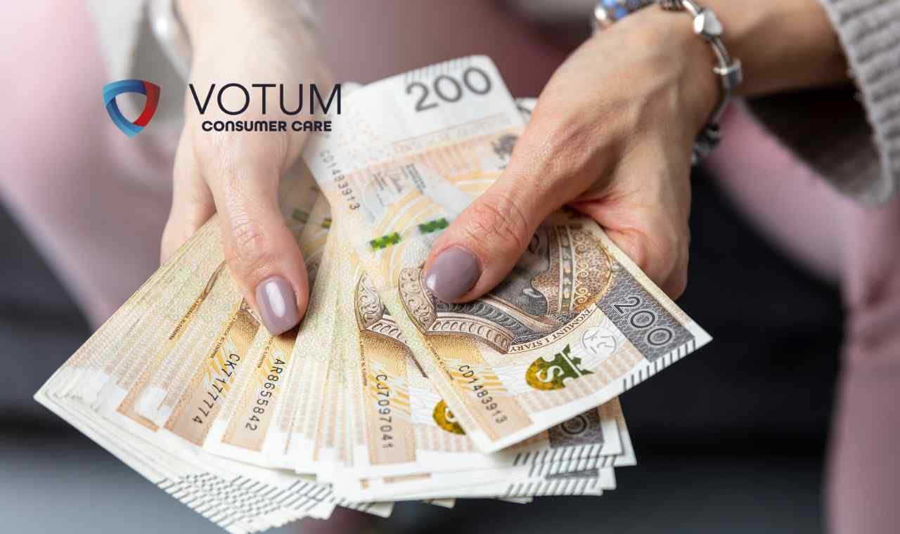 Zbliżenie na dłonie kobiety, która trzyma rozłożony wachlarz banknotów o nominale 200 złotych polskich (PLN).