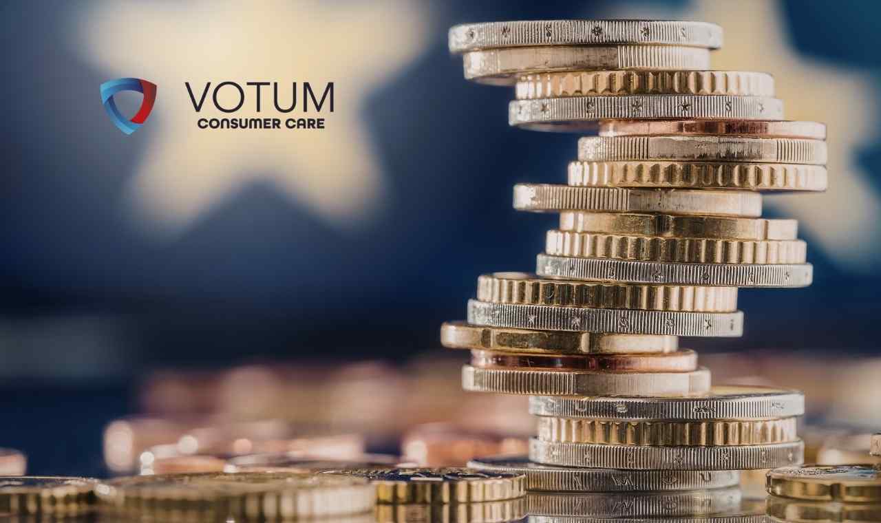 ujęcie wieży ułożonej z monet (euro i złotówek) na rozmytym, ciemnoniebieskim tle, na którym majaczy symbol gwiazdy. W lewym górnym rogu znajduje się logotyp Votum Consumer Care.