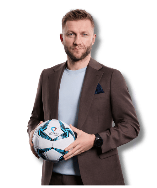 Portret Jakuba Błaszczykowskiego w brązowej marynarce, trzymającego piłkę z logo Votum Consumer Care.