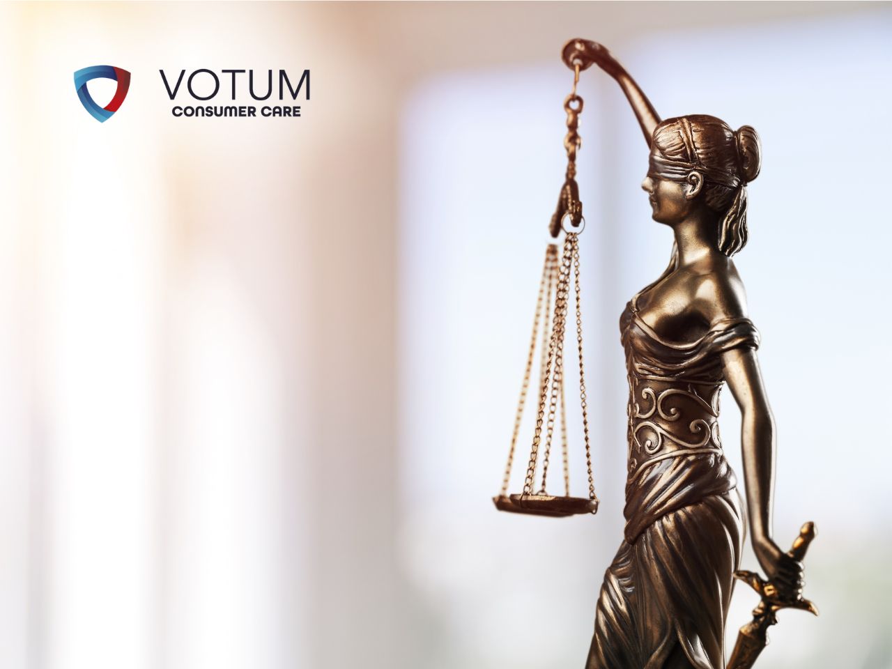 Prawnik w okularach rozmawia przy biurku z parą klientów, tłumacząc zawiłości prawne. Na stole widoczna jest statuetka Temidy oraz otwarte księgi prawnicze. W lewym górnym rogu znajduje się logotyp Votum Consumer Care.