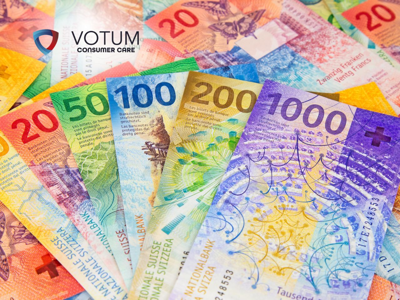 Scena w biurze lub kancelarii; po lewej stronie mężczyzna w ciemnym garniturze i okularach przekazuje dokument kobiecie w beżowej marynarce. W tle widoczny jest drugi mężczyzna, który z niedowierzaniem trzyma się za głowę. Na stole leżą teczki z aktami oraz gazeta.
