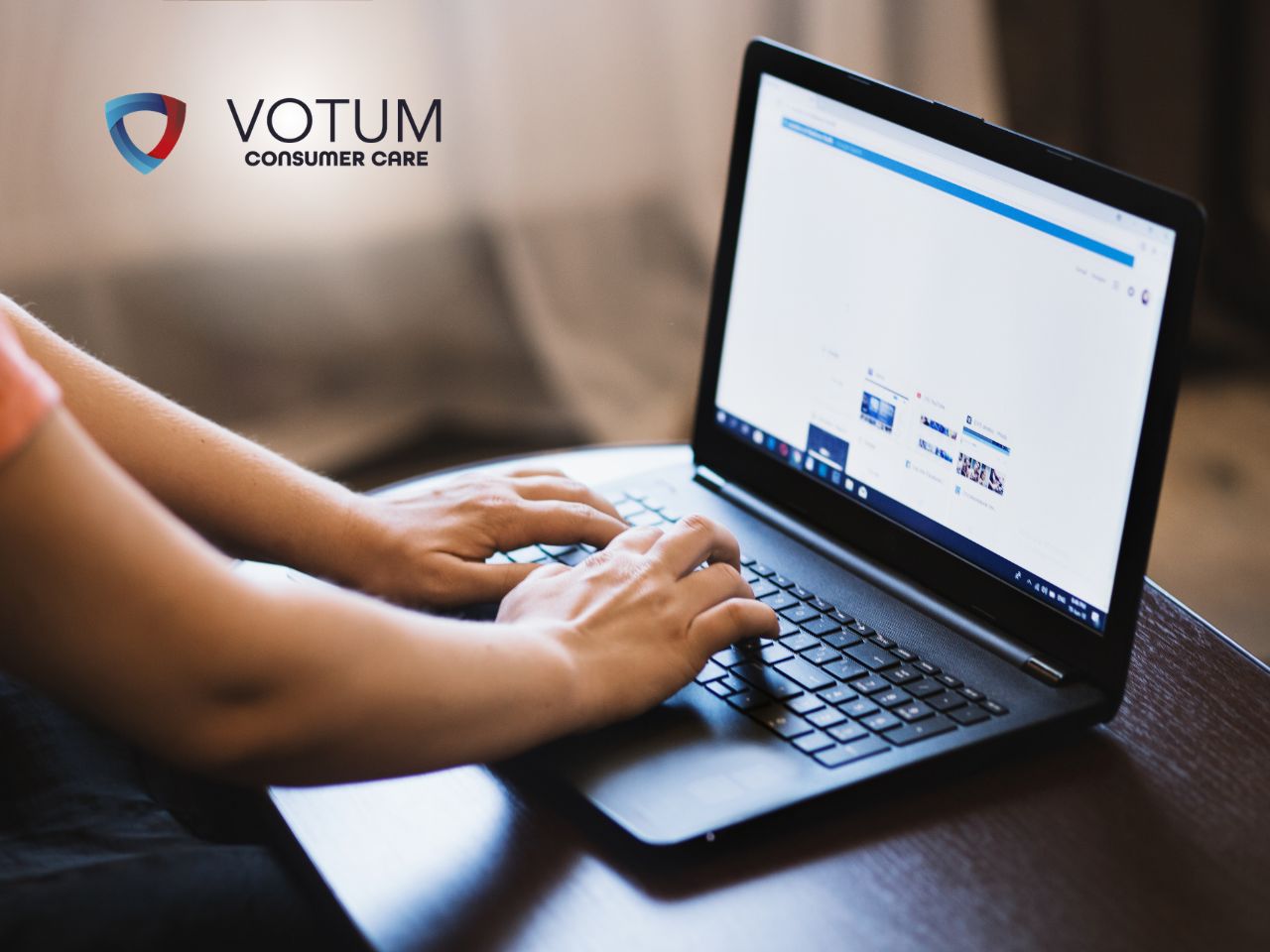 sankcja-kredytu-darmowego-zwrot-odsetek-porady Hands typing on a laptop at a wooden table with the VOTUM Consumer Care logo in the background.